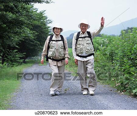 A senior couple walking on a road View Large Photo Image Stock Image - A senior couple walking on a road. Fotosearch