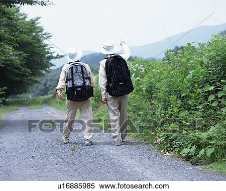 Stock Photography - A senior couple walking on a road. Fotosearch