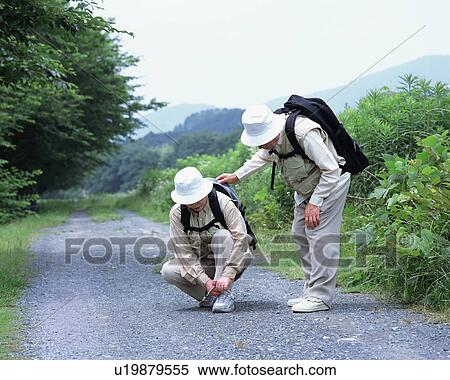 Stock Photography - A senior woman tying lace on shoes. Fotosearch