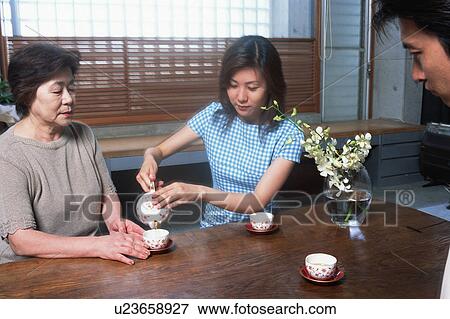 A young woman serving tea View Large Photo Image Stock Photo - A young woman serving tea. Fotosearch