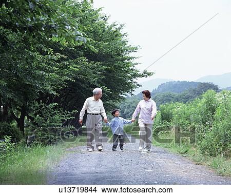 Grand parents walking with a grand son View Large Photo Image Picture - Grand parents walking with a grand son. Fotosearch