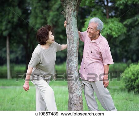 Stock Photo - Senior couple standing under tree. Fotosearch