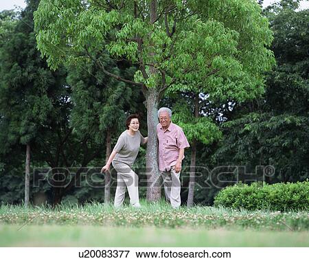 Stock Photo - Senior couple standing under tree. Fotosearch