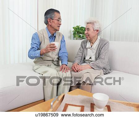 Stock Photo - Senior couple talking in a living room. Fotosearch
