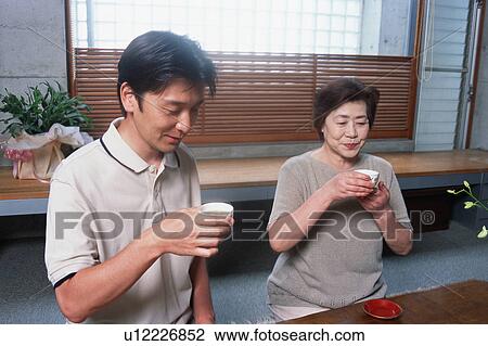 Stock Image - Two people drinking tea. Fotosearch