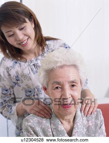 Stock Photo - A daughter giving mother massage. Fotosearch