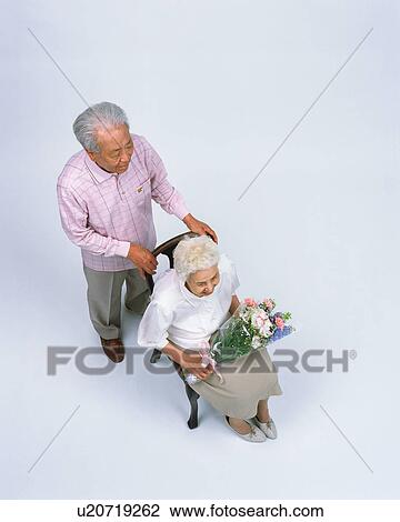 Stock Image - A senior couple sitting in a chair. Fotosearch