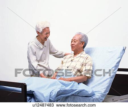 A senior man sitting on a bed View Large Photo Image Stock Image - A senior man sitting on a bed. Fotosearch