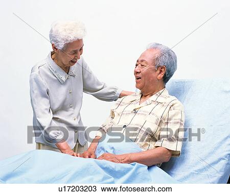 Stock Image - A senior man sitting on a bed. Fotosearch