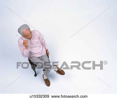 Stock Photo - A senior man talking with cellular phone. Fotosearch