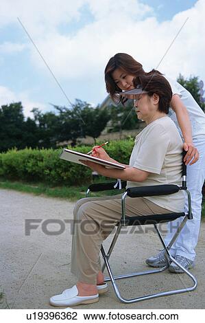 Stock Image - A senior woman drawing a picture. Fotosearch