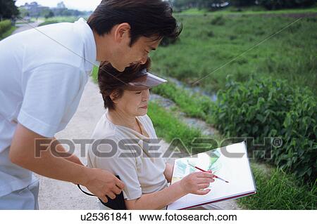 Stock Image - A senior woman drawing a picture. Fotosearch