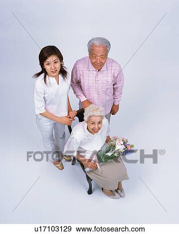 Stock Photo - A senior woman holding flower. Fotosearch