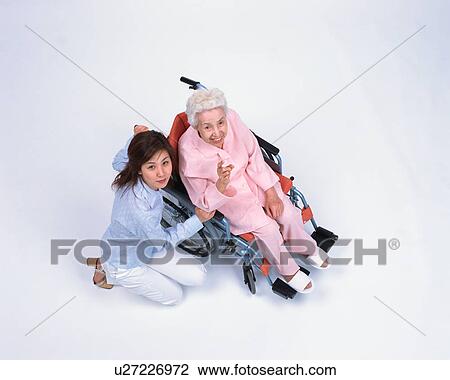 Stock Image - A senior woman in a wheel chair and her granddaughter. Fotosearch