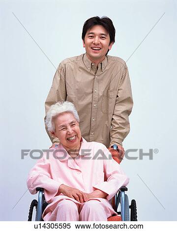 Stock Photography - A senior woman in a wheel chair talking with her grand son. Fotosearch