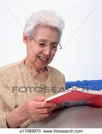 Stock Photography - A senior woman reading a book. Fotosearch
