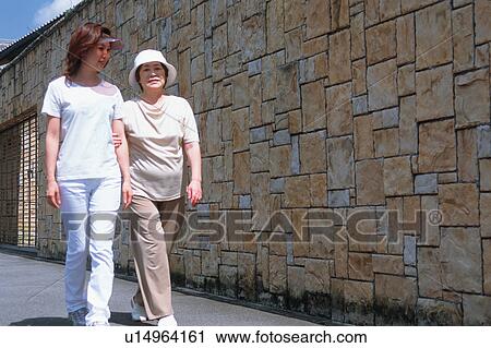A senior woman walking with her daughter View Large Photo Image Stock Image - A senior woman walking with her daughter. Fotosearch