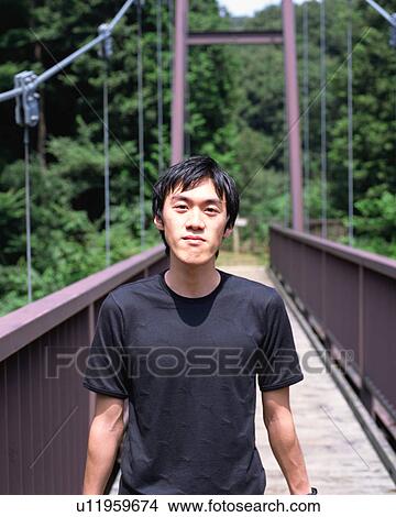Picture - A young man standing in a bridge. Fotosearch