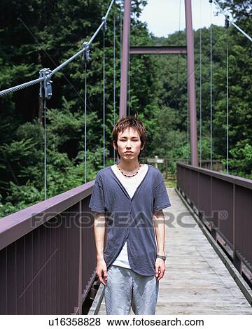 Stock Photo - A young man standing in a bridge. Fotosearch