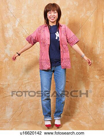 Stock Image - A young woman jumping. Fotosearch