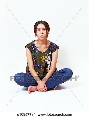 Picture - Portrait of a young woman sitting with her legs crossed. Fotosearch