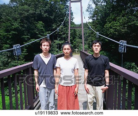 Three young people standing in a bridge View Large Photo Image Stock Image - Three young people standing in a bridge. Fotosearch