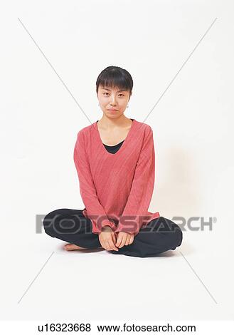 A young woman sitting with her legs crossed View Large Photo Image Stock Photo - A young woman sitting with her legs crossed. Fotosearch