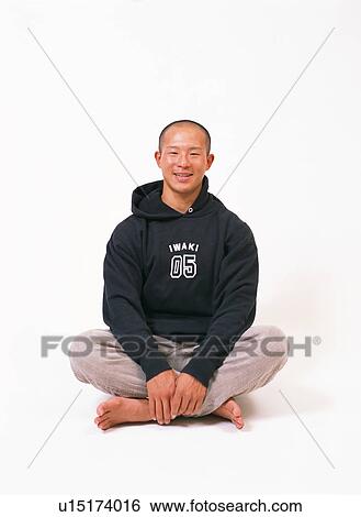 Stock Photograph - A young woman sitting with his legs crossed.. Fotosearch