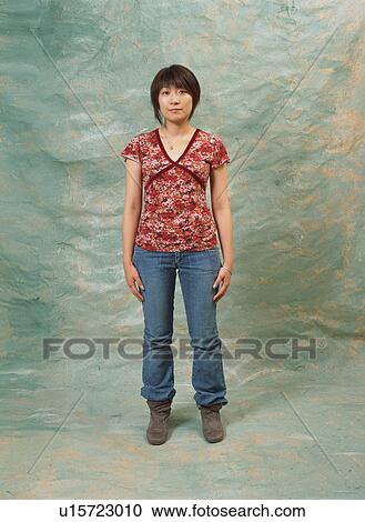 Stock Image - Portrait of a young woman standing. Fotosearch