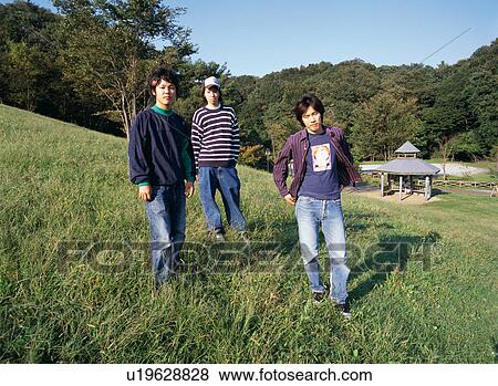 Stock Photo - Three young men standing in fields. Fotosearch