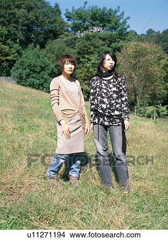 Picture - Two young women standing in fields. Fotosearch