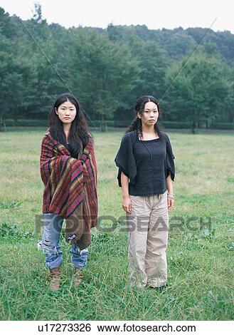 Stock Photograph - Two young women standing in fields. Fotosearch