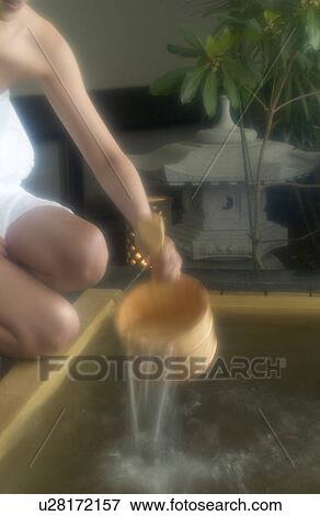 Stock Photo - A young woman bathing in hot springs. Fotosearch