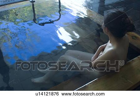 Stock Photograph - A young woman bathing in hot springs. Fotosearch