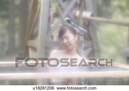 Stock Photograph - A young woman bathing in hot springs. Fotosearch