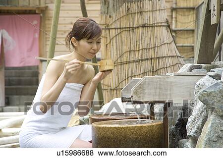 A Young woman drinking spring water View Large Photo Image Stock Photo - A Young woman drinking spring water. Fotosearch