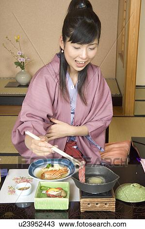 Stock Image - A Young Women eating dinner in Japanese style inn. Fotosearch