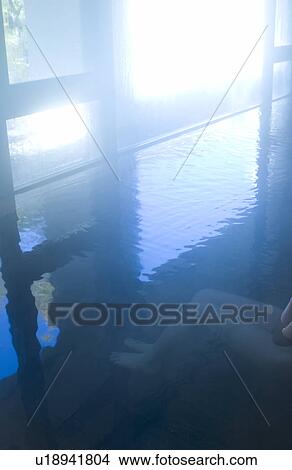 Picture - Low section of a woman bathing in hot springs. Fotosearch