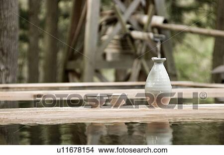 Picture - Sake bottle and cups at hot springs in Japan. Fotosearch