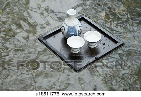 Stock Photograph - Sake bottle floating on hot water. Fotosearch
