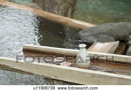 Stock Photo - Sake bottle in hot water. Fotosearch