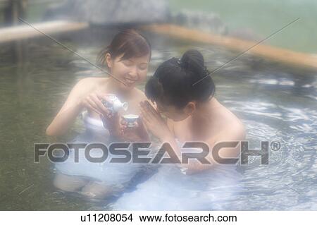 Picture - Two young women bathing in hot springs. Fotosearch