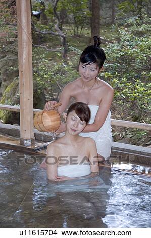 Picture - Two young women bathing in hot springs. Fotosearch