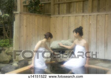 Stock Image - Two young women bathing in hot springs. Fotosearch