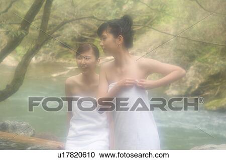 Stock Image - Two young women bathing in hot springs. Fotosearch