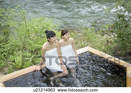 Stock Image - Two young women bathing in hot springs. Fotosearch