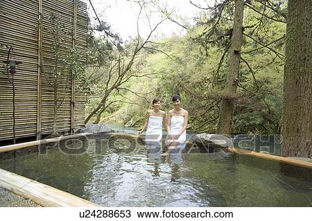 Stock Image - Two young women bathing in hot springs. Fotosearch