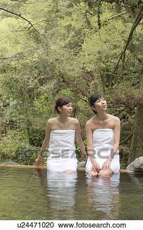 Stock Image - Two young women bathing in hot springs. Fotosearch