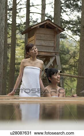 Stock Image - Two young women bathing in hot springs. Fotosearch
