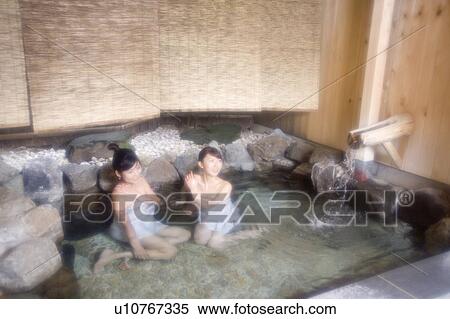 Stock Photography - Two young women bathing in hot springs. Fotosearch